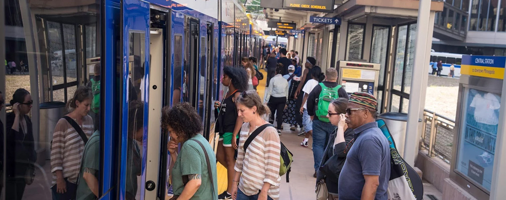 Photo shows passengers on a platform boarding a train.