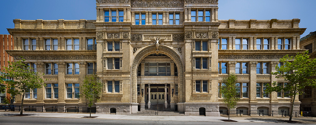 Photograph of Drexel’s Main Building, a four-story brick structure with terra cotta reliefs and sculptures