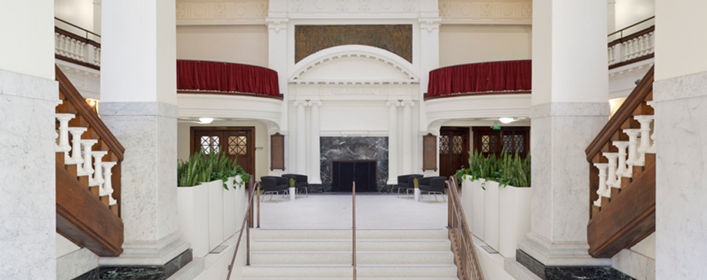 Photograph of the top of the grand staircase with the lobby in the background.