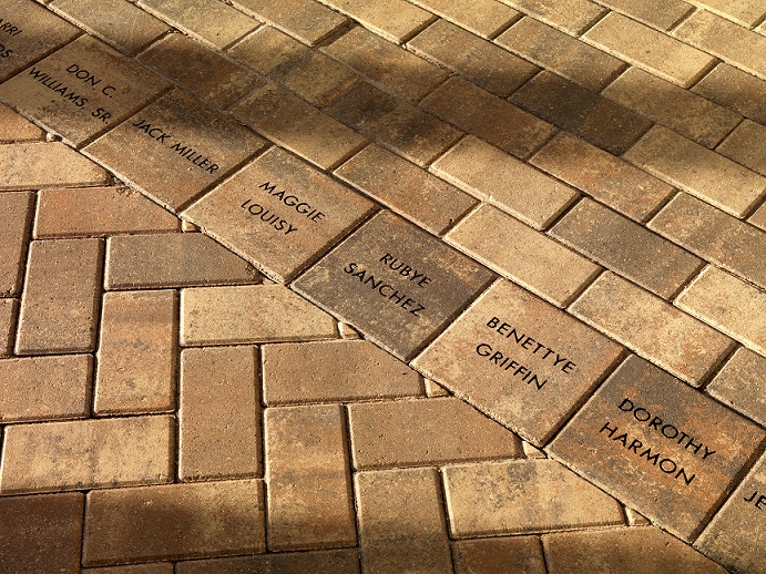 A picture of a portion of the memorial brick walkway. Eight of the bricks are stamped with the names of congregation members.
