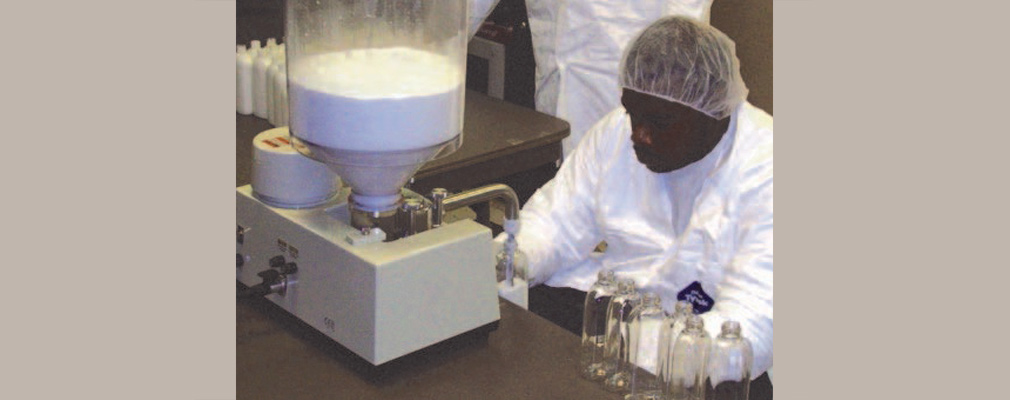 Photograph of a Sweet Beginnings employee using processing equipment.