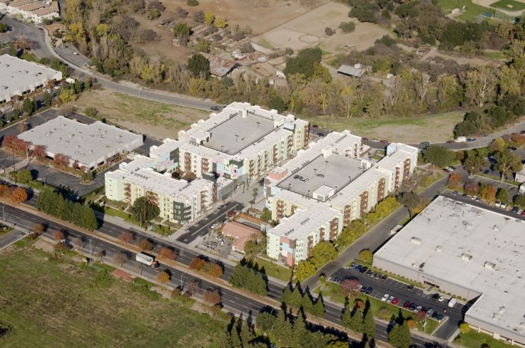 Low-angle aerial view of Paseo Senter, showing two buildings, one on either side of the paseo. Each building includes a parking structure encased with residential units for the entire height of the structure (Courtesy of Steve Proehl).