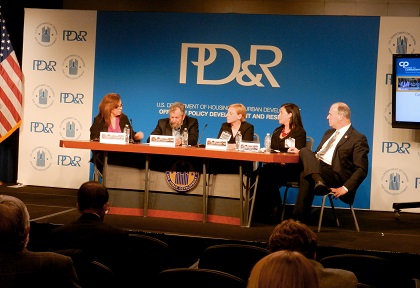 Moderator Yolanda Chavez of HUD, Alan Mallach of the Brookings Institution, Terry Schwarz of Kent State University's Cleveland Urban Design Collaborative, Sara Toering of the Center for Community Progress, and U.S. Congressman Dan Kildee sit at a table in front of a PD&R banner, speaking to a seated crowd visible in the foreground.
