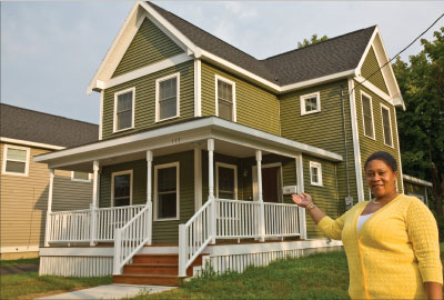 Homeowners such as Aishon Jones, standing in front of her new home in Syracuse, New York, seek the economic and social benefits associated with successful homeownership.