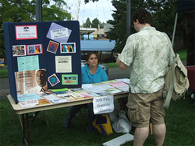 A table top display by the Northwest Fair Housing Alliance showing brochures, flyers, and other fair housing materials.