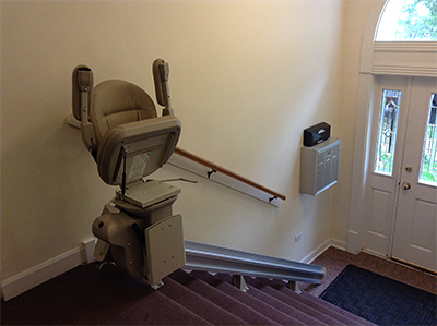 A chairlift installed along a flight of stairs inside a building.