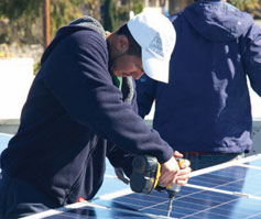 Hector del Real, a former YouthBuild job trainee shown here installing solar panels on a multifamily retrofit, is now a full-time employee with Everyday Energy in one of the new kinds of jobs generated by clean energy initiatives.