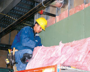 Image of a worker setting up inside a building.