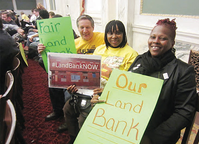Demonstrators in front of Philadelphia’s City Hall holding signs advocating passage of a land bank bill.