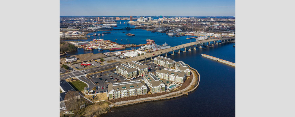Aerial view of apartment buildings and an active waterfront.