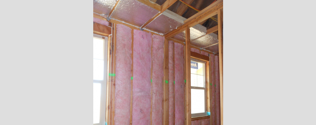 Photograph of insulation in the wall of a residential building under construction.