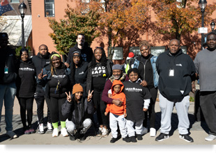 A posed group photograph of smiling people wearing Lead Safe Resource Center t-shirts.