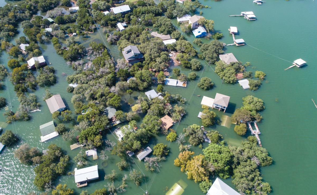 An aerial view of buildings and trees partially submerged under water.