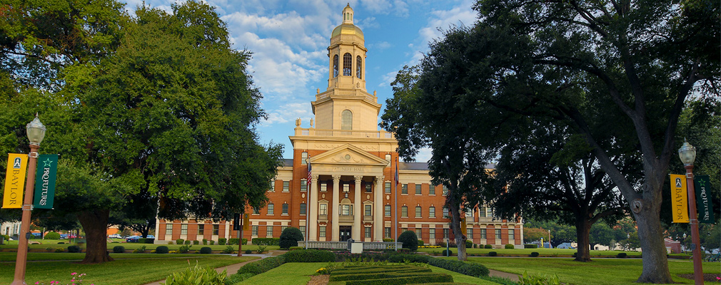 Photograph of the front façade of Baylor University’s historic Pat Neff Hall, a three-story brick building with a gabled portico and tower marking the entrance.