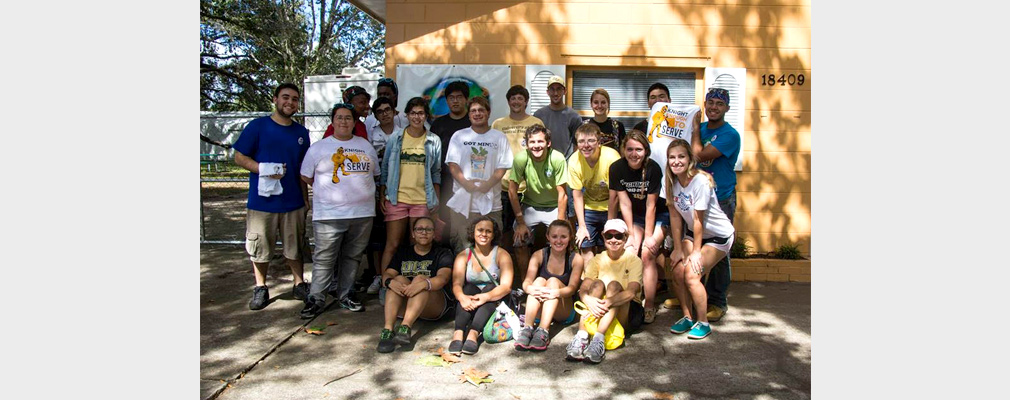 Photograph of 21 University of Central Florida student volunteers standing in front of an Orange County Academy building.