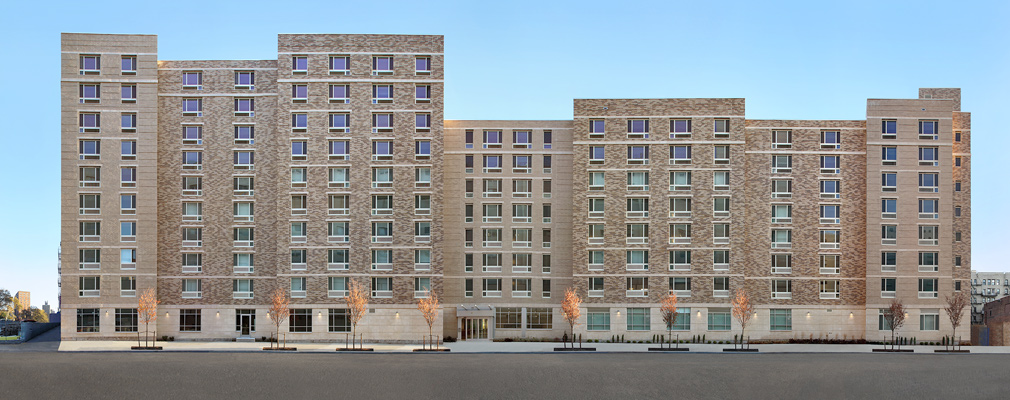 Photograph of the front façade of a brick residential building with 8- and 10-story sections.