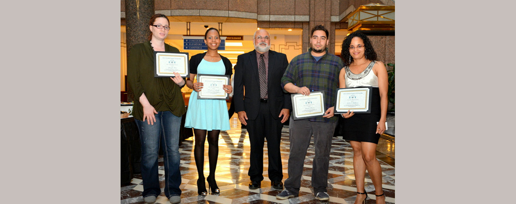 Photograph of four scholarship winners standing with SINA’s executive director, Melvyn Colón.
