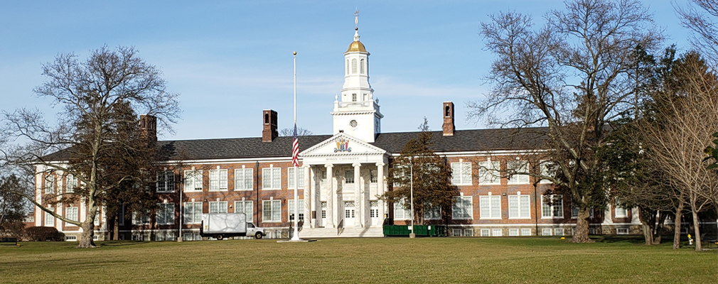 Photograph of the front façade of Bunce Hall, a three-story academic building constructed in 1922, with a pedimented portico and cupola marking the building entrance.