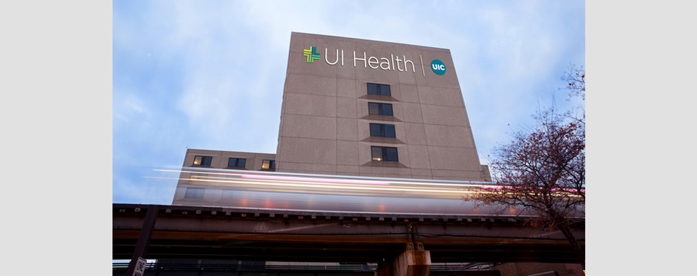 Photograph of a multistory medical building with a façade sign reading “UI Health|UIC.”