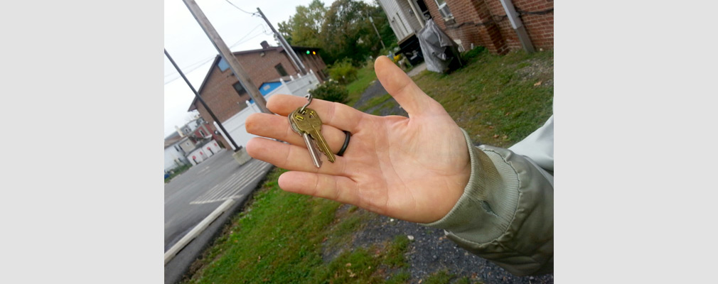 Photograph of a hand holding a set of two house keys.