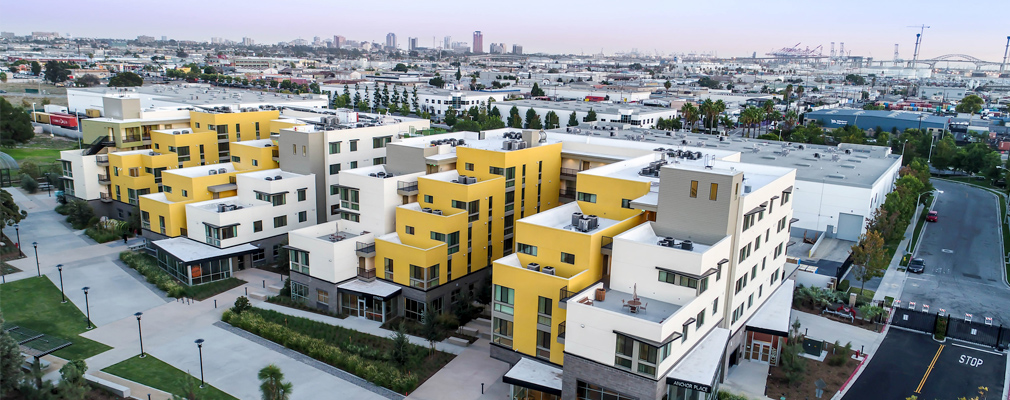 Photograph of Anchor Place, multistory residential building with four wings, in the foreground with the surrounding area of Long Beach, California, in the background.