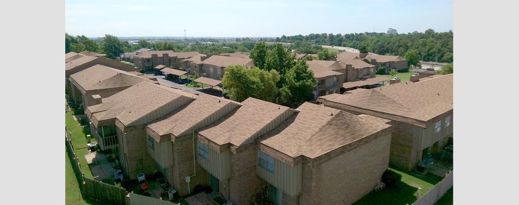 Low-angle aerial photograph of a community of two-story apartment buildings.