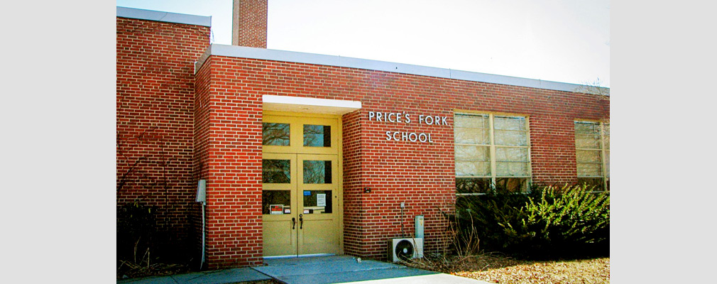 Photograph of the entrance of a one-story brick school building prior to renovation.