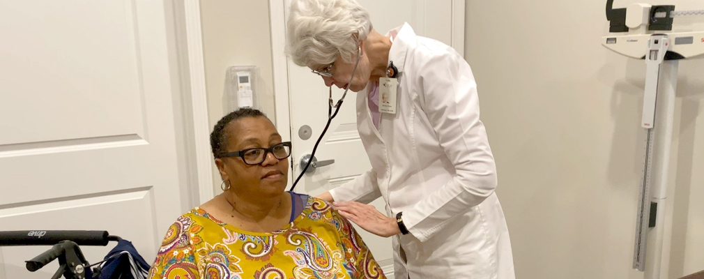 Photograph of a nurse examining a patient in a medical office.