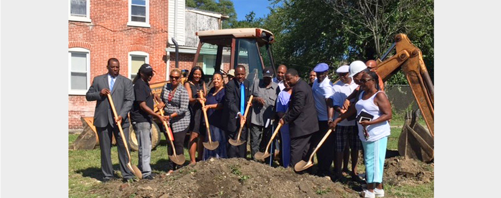 Photograph of 17 people holding shovels as part of a groundbreaking ceremony.