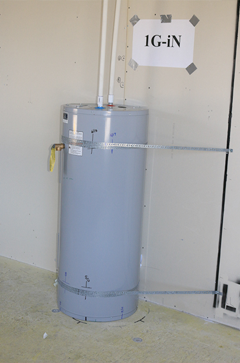 Photograph of a water heater braced to the wall behind it.