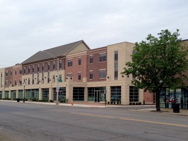 Photograph of the front façade of a three-story mixed use building along a commercial street.