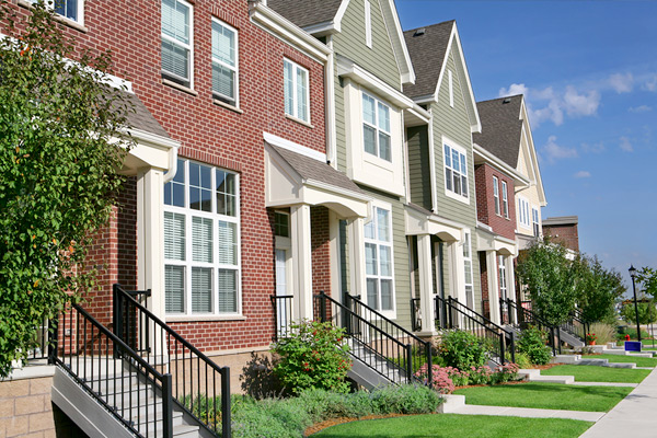 Photo showing the front facades of a row of two-story townhouses on a suburban street
