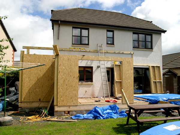 Photograph of the back of a detached single family home undergoing renovation.