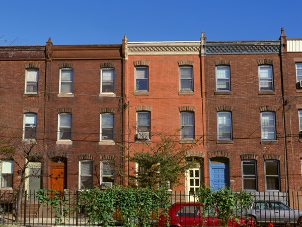 Image of three-story brick rowhouses on a city block.