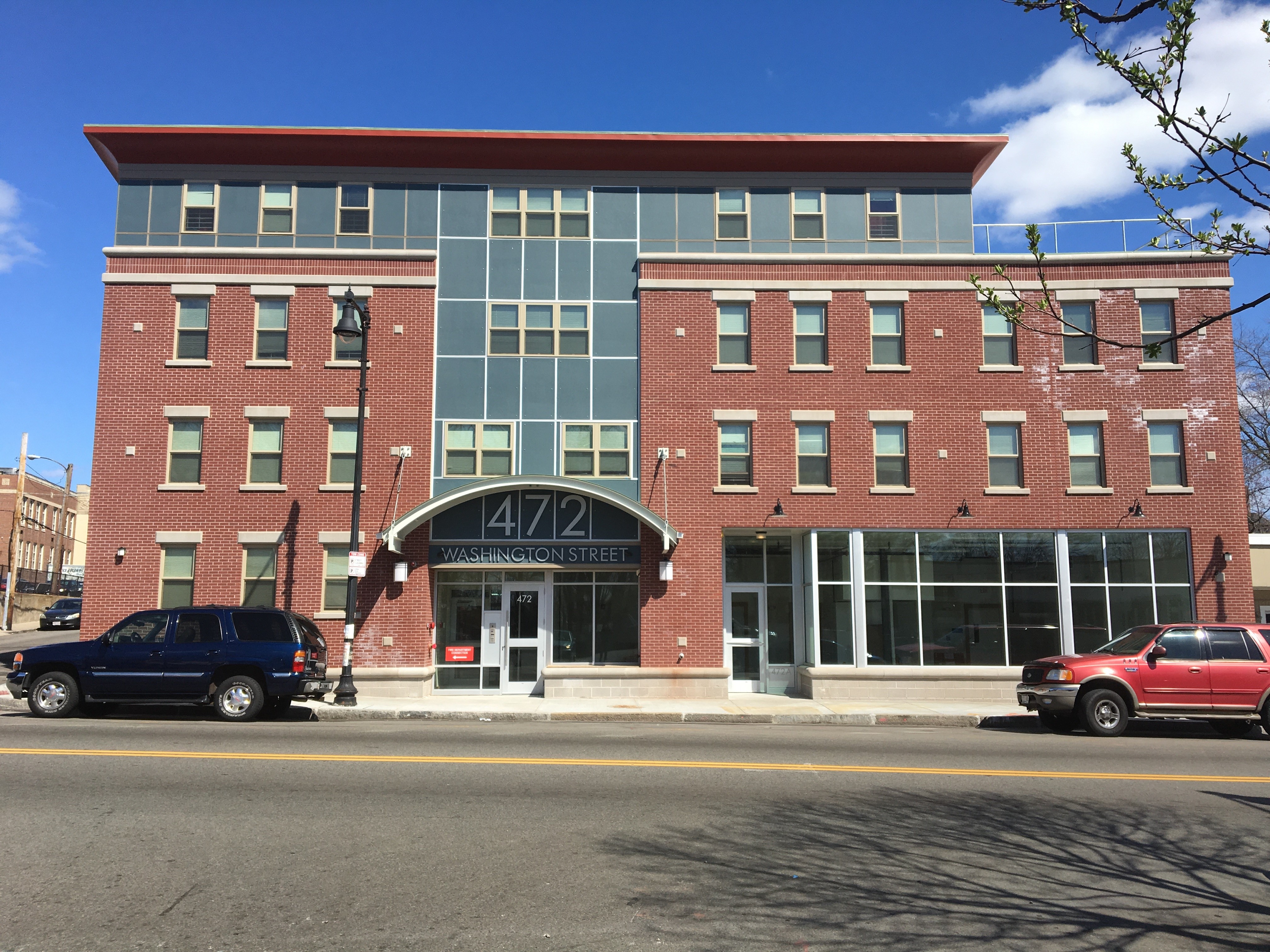 Photograph of newly constructed 4-story building with 8 units on top of first floor commercial space in Boston’s Codman Square neighborhood.
