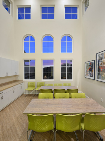 Image of tables and chairs in a room with large windows.