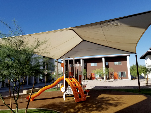 Photograph of a playground with a large sun awning.