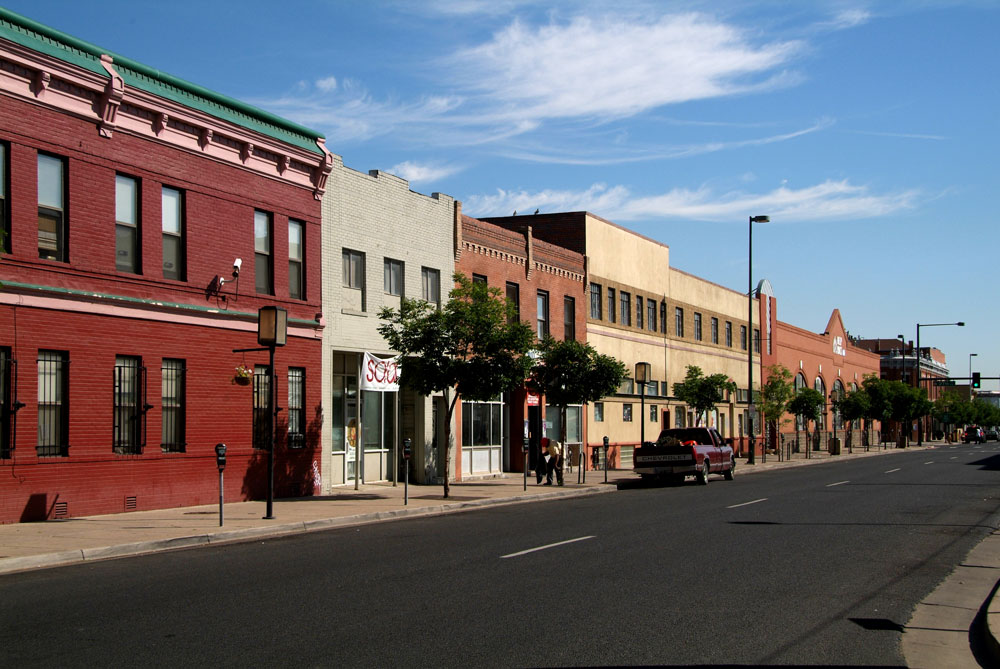 Photograph of two-story commercial buildings along a street. 