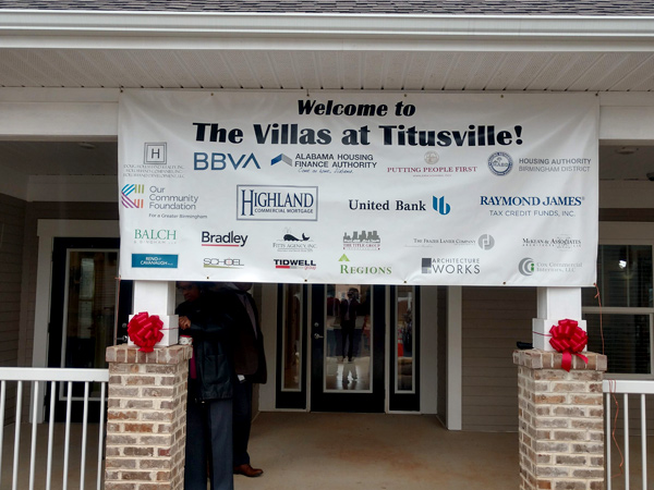 Photograph of a banner with the title “Welcome to the Villas at Titusville” and listing over groups involved in project development.