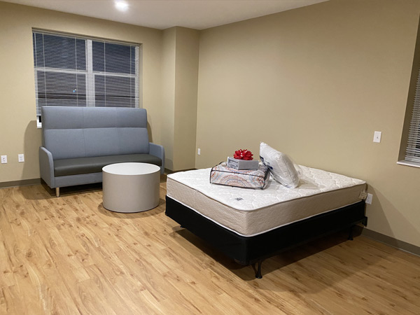 Image of a studio apartment with a bed and small sofa.