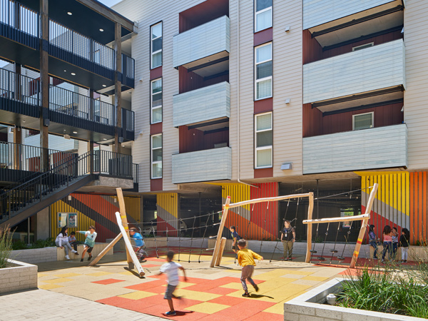 Image of children playing in a brightly colored apartment courtyard.