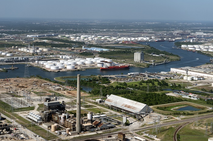 Image of an oil refinery facility in Houston, Texas, in which industrial processing equipment is located around a winding river. 