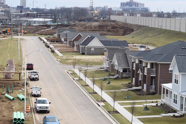 Photograph of nine completed houses, with ongoing construction in the background.