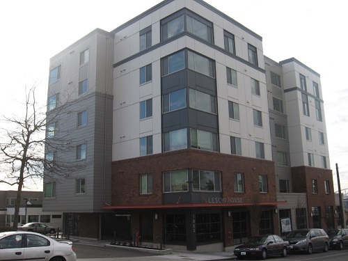 Photograph of a six-story building, with residences above first-floor commercial uses.