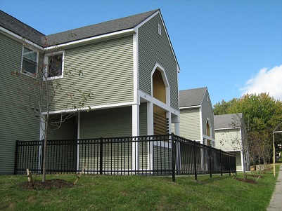 Photograph of a two-story residential building with wood siding.