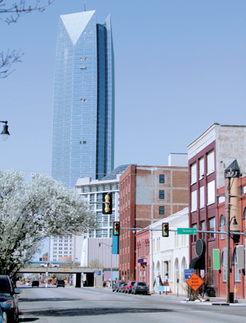 Photo shows buildings in downtown Oklahoma City with a skyscraper in the background.