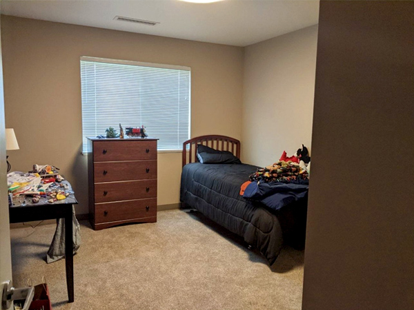 Photo of a child’s bedroom with toys on the table and dresser.