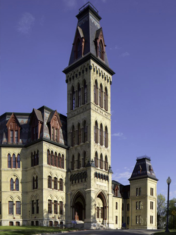 Front façade of a historic four-story building with a tower in front.