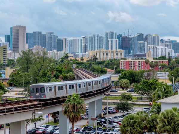 Photo of the Miami Metrorail with multiple skyscrapers in the background.