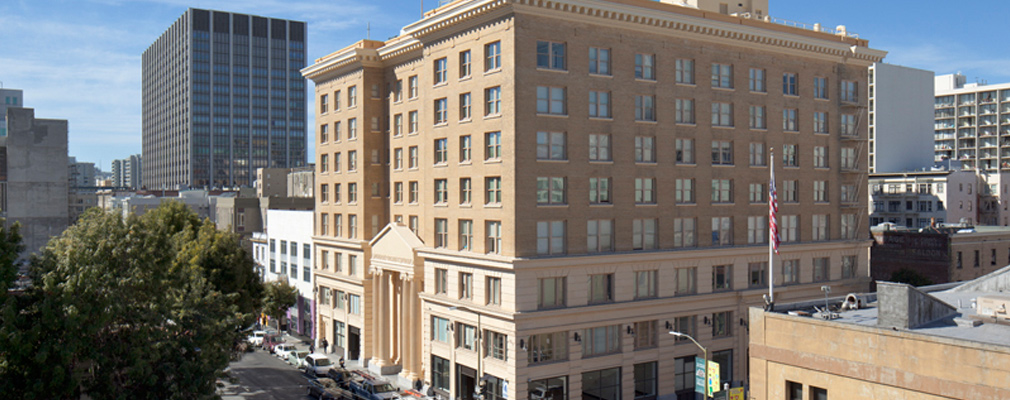 Photograph of the two street façades of an nine-story masonry building with classical details.